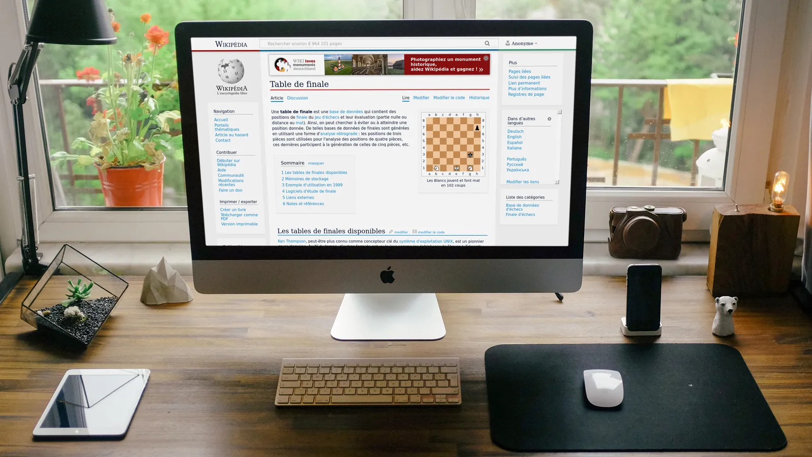 A desktop monitor on a design workspace showing a website layout mockup