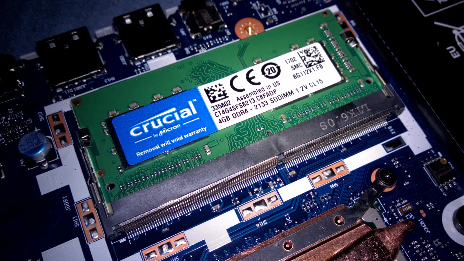 A Crucial DDR4 laptop RAM module installed in a laptop motherboard memory slot