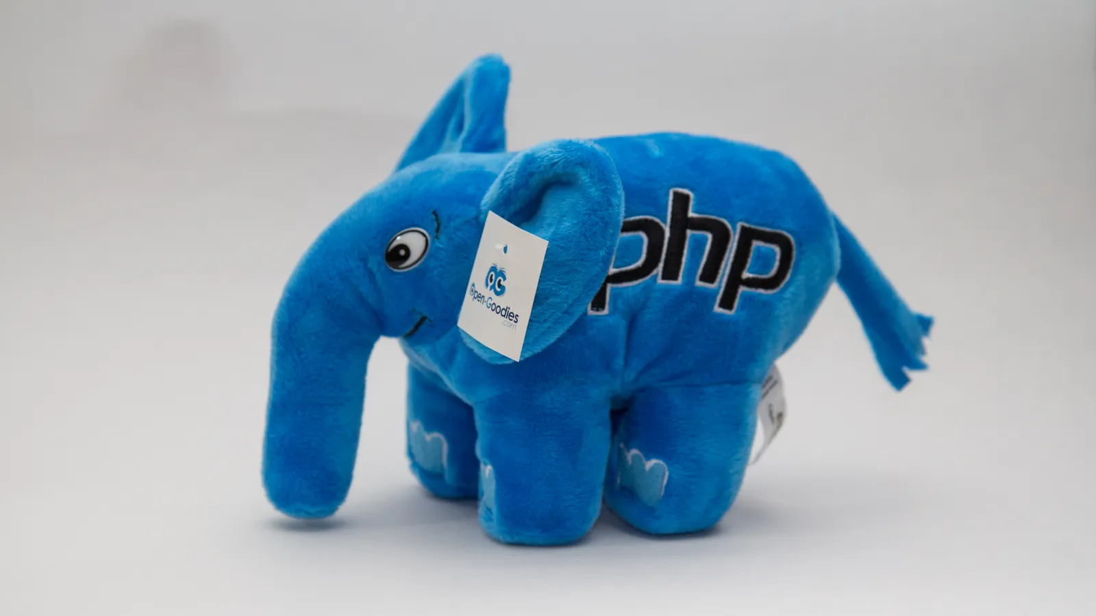 A blue plush elePHPant, the PHP mascot, with the PHP logo stitched on its side